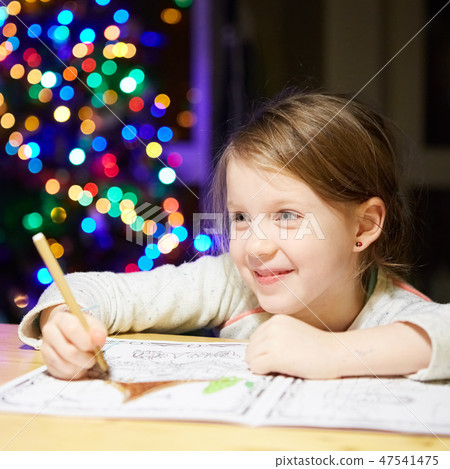 Inspired little girl at the table draw with crayons or do home work Inspired little girl at the table draw with crayons or do home work 47541475
