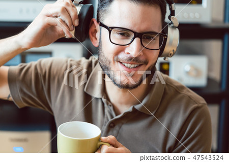 Man drinking coffee and listening to music Man drinking coffee and listening to music 47543524