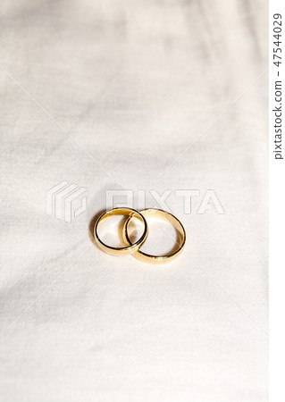 Two golden wedding rings on the white fabric. Two golden wedding rings on the white fabric. 47544029