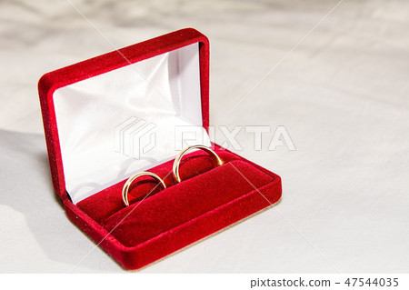 Two golden wedding rings on the white fabric. Two golden wedding rings on the white fabric. 47544035