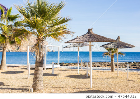 Sun umbrellas made of palm leaves on the beach Sun umbrellas made of palm leaves on the beach 47544312