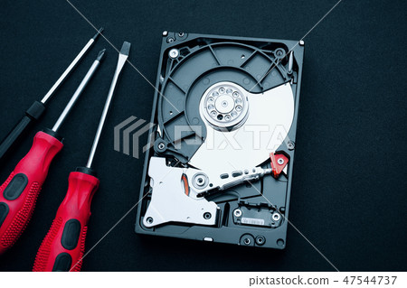 Uncovered hard disk drive and screwdrivers Uncovered hard disk drive and screwdrivers 47544737