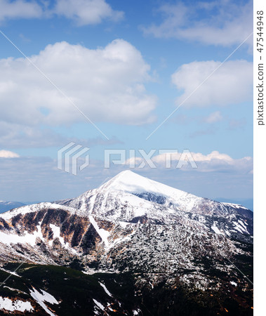 View of the stony hills with snow and blue sky 47544948