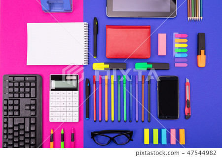 Top view of business desk composite with smartphone, calculator, stickers, and colored pens on pink Top view of business desk composite with smartphone, calculator, stickers, and colored pens on pink 47544982