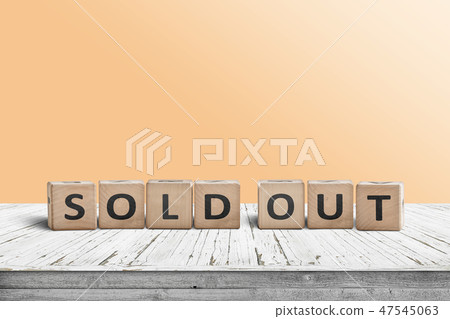 Sold out sign on a wooden table with a yellow wall 47545063