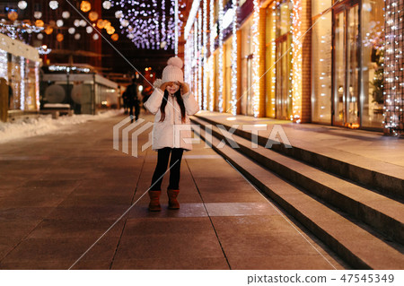 Cute scared lost little girl in a big city in the evening in winter Cute scared lost little girl in a big city in the evening in winter 47545349