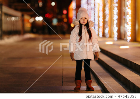 Cute happy little girl walks on the streets of a big city 47545355