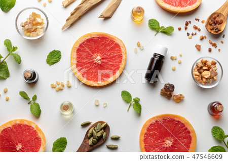 Bottles of essential oil with grapefruit and herbs 47546609