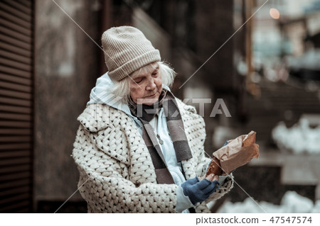 Nice aged homeless woman taking out the bun 47547574