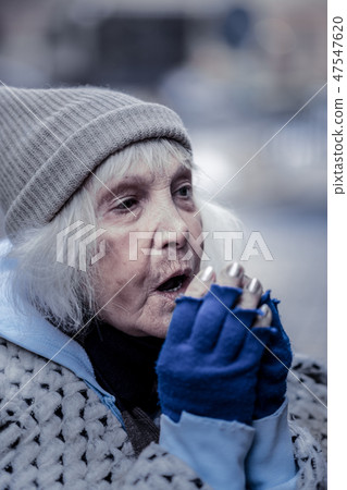 Depressed aged woman breathing at her hands 47547620