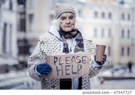 Sad aged woman asking people for help 47547727