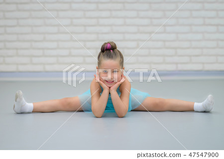 Cute little beautiful girl doing splits at ballet class. Young happy ballerina in blue dress 47547900