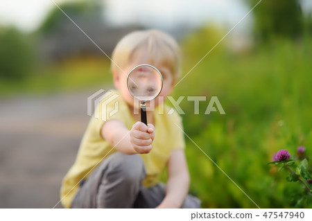 Little boy playing with magnifying glass. Little boy playing with magnifying glass. 47547940