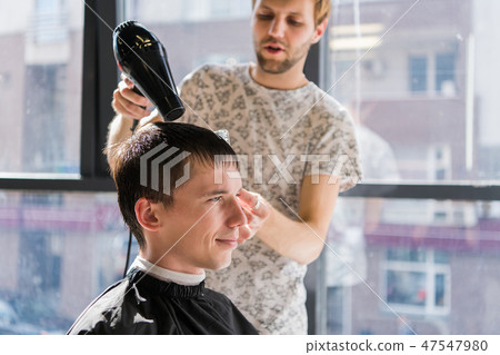 Drying, styling men's hair in a beauty salon Drying, styling men's hair in a beauty salon 47547980