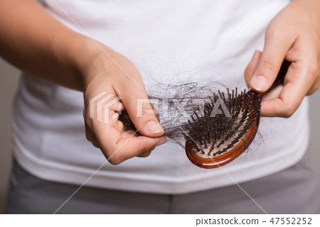 Woman show her brush with long loss hair 47552252