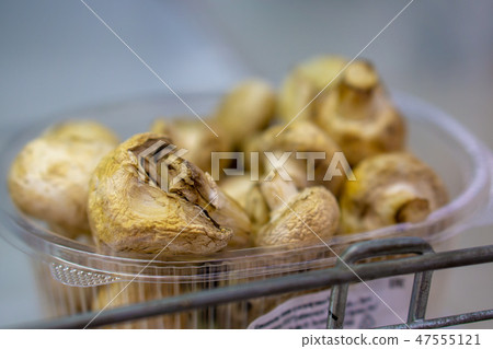 Stale mushroom champignon on the store shelf. Close-up, spoiled food 47555121