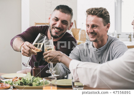 Gay couple having dinner party with friend at home Gay couple having dinner party with friend at home 47556891