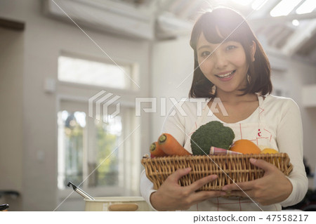 Young housewife with vegetables cooking cooking Young housewife with vegetables cooking cooking 47558217