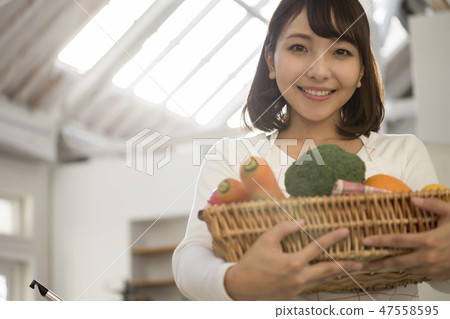 Young housewife with vegetables cooking cooking Young housewife with vegetables cooking cooking 47558595