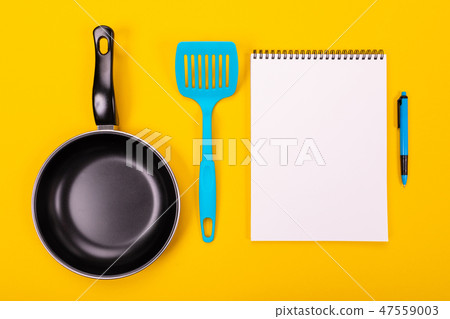 Kitchen utensils and clean sheet of paper isolated on yellow background Kitchen utensils and clean sheet of paper isolated on yellow background 47559003