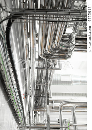 Steel pipelines and cables in factory interior as pharmaceutical industry background concept 47559124