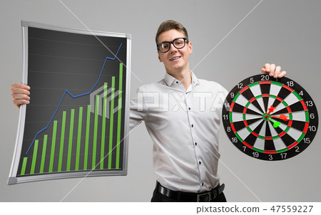 Young man in glasses holding a Board with increasing statistics and Darts isolated on white 47559227