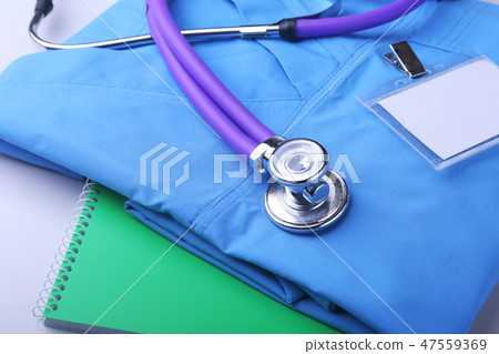 Medical stethoscope lying on a blue doctor's form and notepad close-up. the therapist's work space. Medical stethoscope lying on a blue doctor's form and notepad close-up. the therapist's work space. 47559369