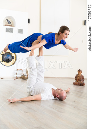 Fit young woman balancing on man's feet 47559772