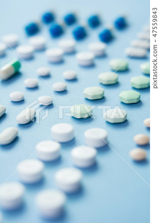 Medical tablets on light blue background 47559843