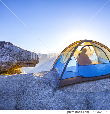 Man inside a tent in Yosemite at sunrise Man inside a tent in Yosemite at sunrise 47562103