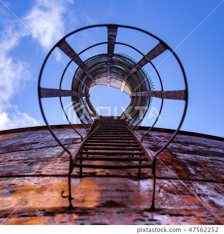 Ladder of an old gas tank under clear blue sky Ladder of an old gas tank under clear blue sky 47562252