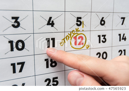 The hand points the finger on the calendar on the The hand points the finger on the calendar on the 47565923
