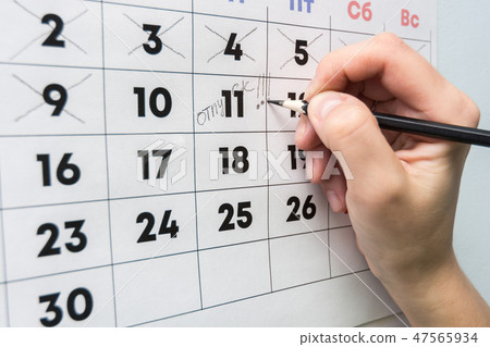 The hand with a pencil writes the word vacation The hand with a pencil writes the word vacation 47565934
