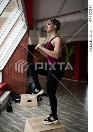 Woman with step platform doing cross fit exercise. Studio shot 47567853