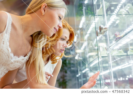 Two Girl Are Looking at Jewelry Shop Display Window Two Girl Are Looking at Jewelry Shop Display Window 47568342
