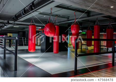 Red punching bags with gym background. Pears for boxing Red punching bags with gym background. Pears for boxing 47568478
