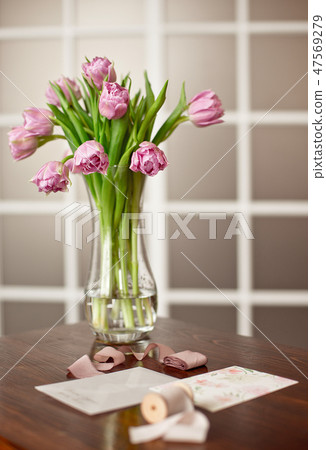 Lavender purple flowers in a golden vase on a wooden table in an elegant interior with greeting Lavender purple flowers in a golden vase on a wooden table in an elegant interior with greeting 47569279