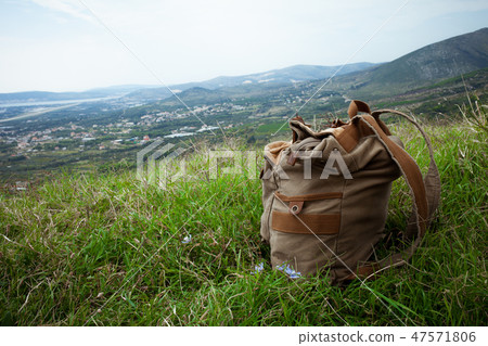 backpack on the grass at the top of the mountain 47571806