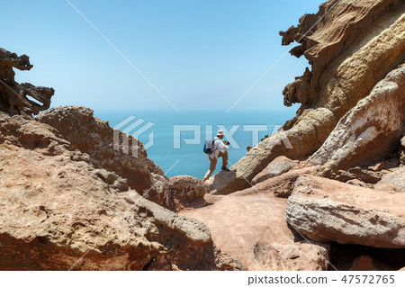 Tourist climbs rock to make good shot of nature. 47572765