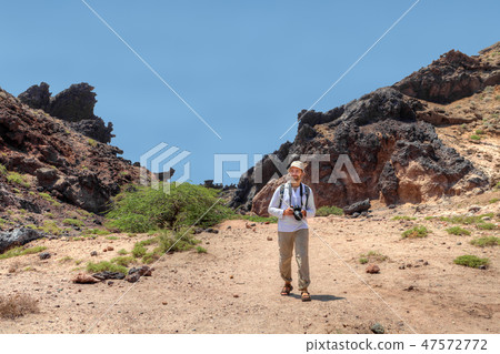 Photographer traveler walking in Hormoz Island 47572772
