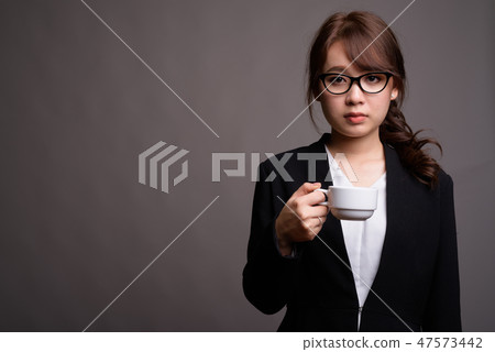 Young beautiful Asian businesswoman holding coffee cup 47573442