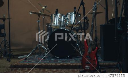 Red bass guitar on a home musical studio. Red bass guitar on a home musical studio. 47574255