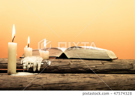Bible and candle on a old oak wooden table. Bible and candle on a old oak wooden table. 47574328