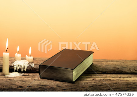 Holy Bible and candle on a old oak wooden table. Holy Bible and candle on a old oak wooden table. 47574329