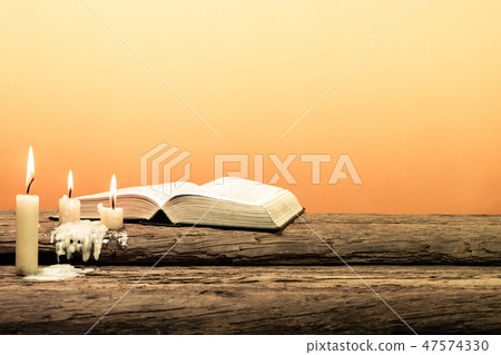 Open Bible and candle on a old oak wooden table. Open Bible and candle on a old oak wooden table. 47574330