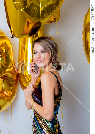 woman with golden balloons and mobile phone 47574924