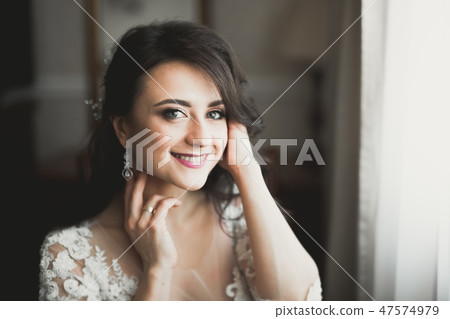 Beautiful bride wearing fashion wedding dress with feathers with luxury delight make-up and Beautiful bride wearing fashion wedding dress with feathers with luxury delight make-up and 47574979