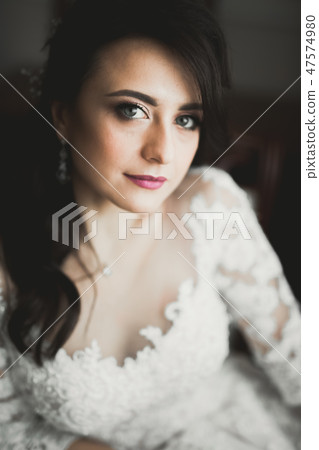 Beautiful bride wearing fashion wedding dress with feathers with luxury delight make-up and Beautiful bride wearing fashion wedding dress with feathers with luxury delight make-up and 47574980