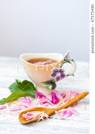 Cup of green tea and spring peonies blossom on a old wooden background. Rustic. 47575490