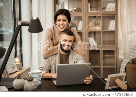 Laughing appealing woman leaning on the back of her husband Laughing appealing woman leaning on the back of her husband 47575666